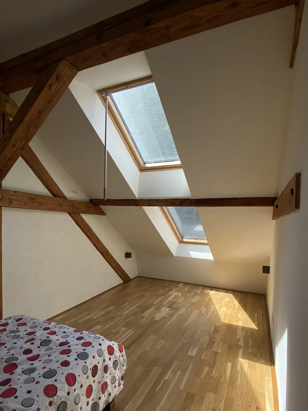 Dormitorul apartamentului 9, cu fereastra de acoperiș deasupra patului