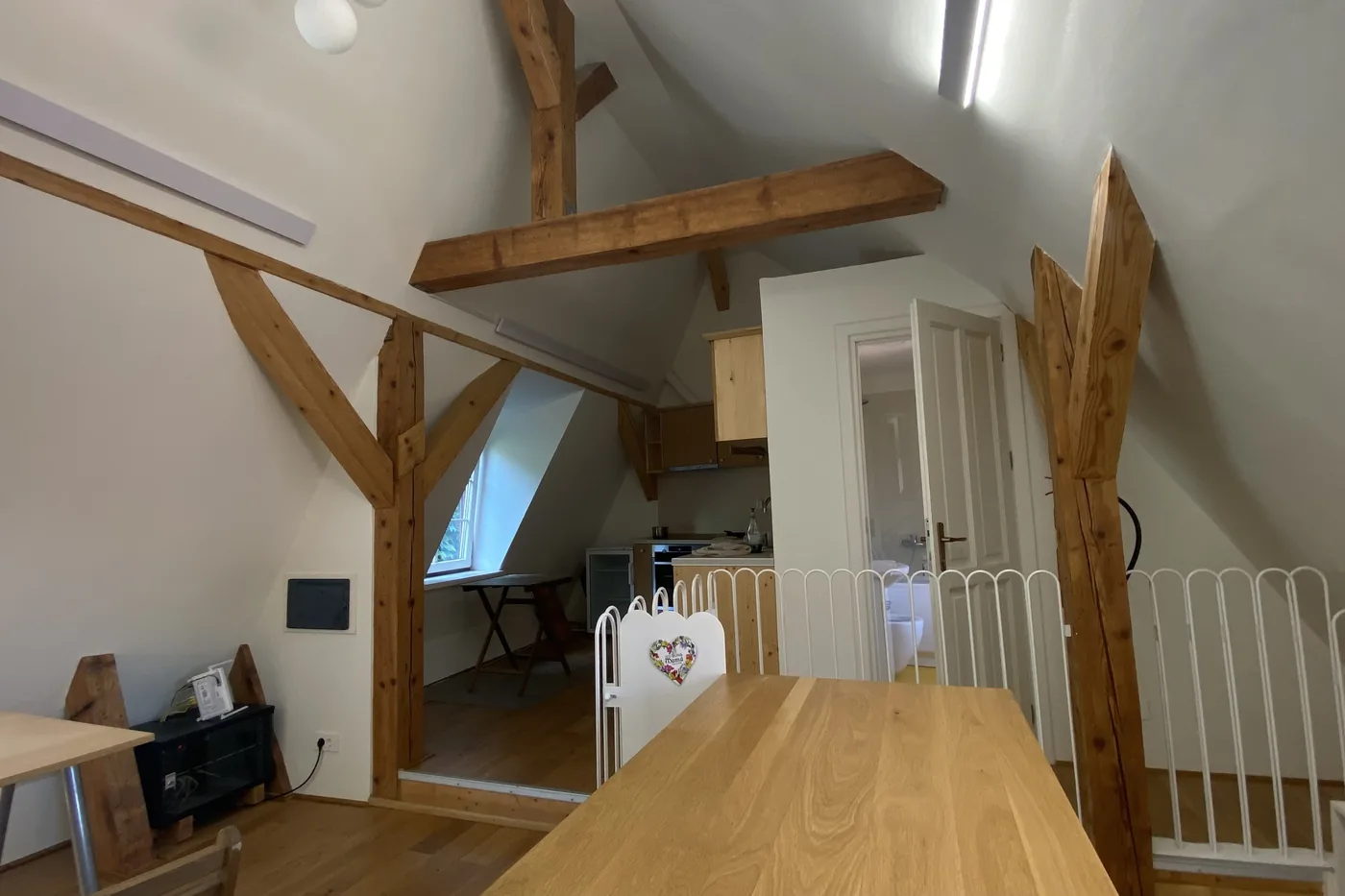 Masa din apartamentul 9, cu balustrada galeriei și bucătăria în spate